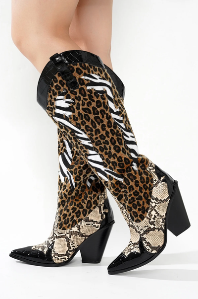 Knee-high cowboy boots with black pointed toe and block heel, featuring panels of leopard print, zebra stripes, and snakeskin pattern, separated by black trim.