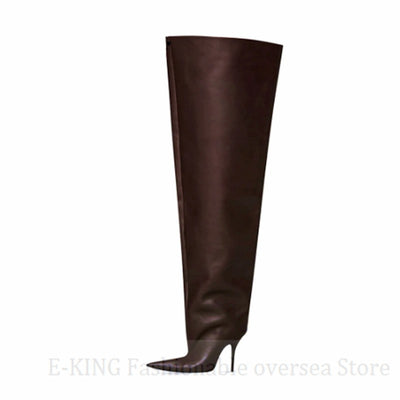 Embrace a bold and avant-garde aesthetic with these exaggerated brown thigh-high boots, showcasing a loose-fitting shaft, towering platform soles, and a pointed toe